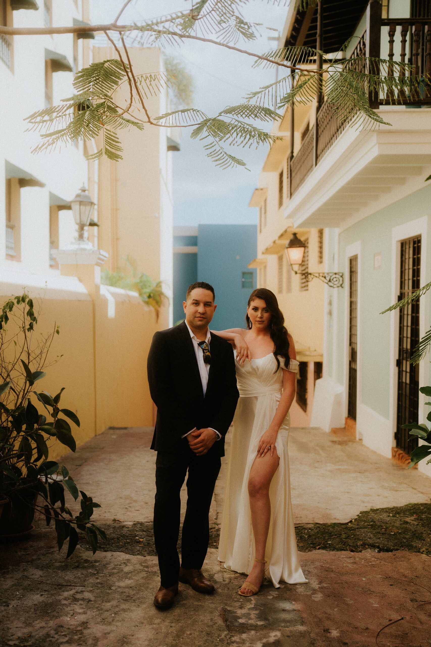 Elopement in Old San Juan. Couple in wedding attire pose like models in the alleys of San Juan