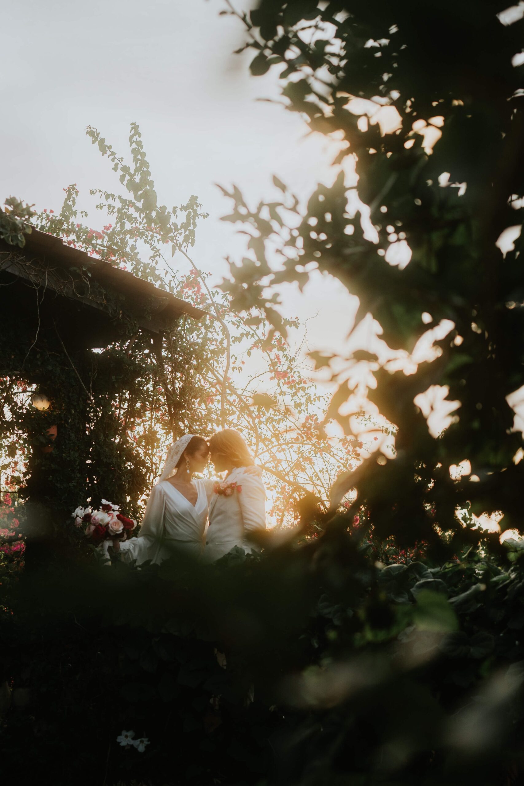 Sunset Wedding at Hacienda Siesta Alegre. Couple in wedding attire lean together as the sun falls behind them.