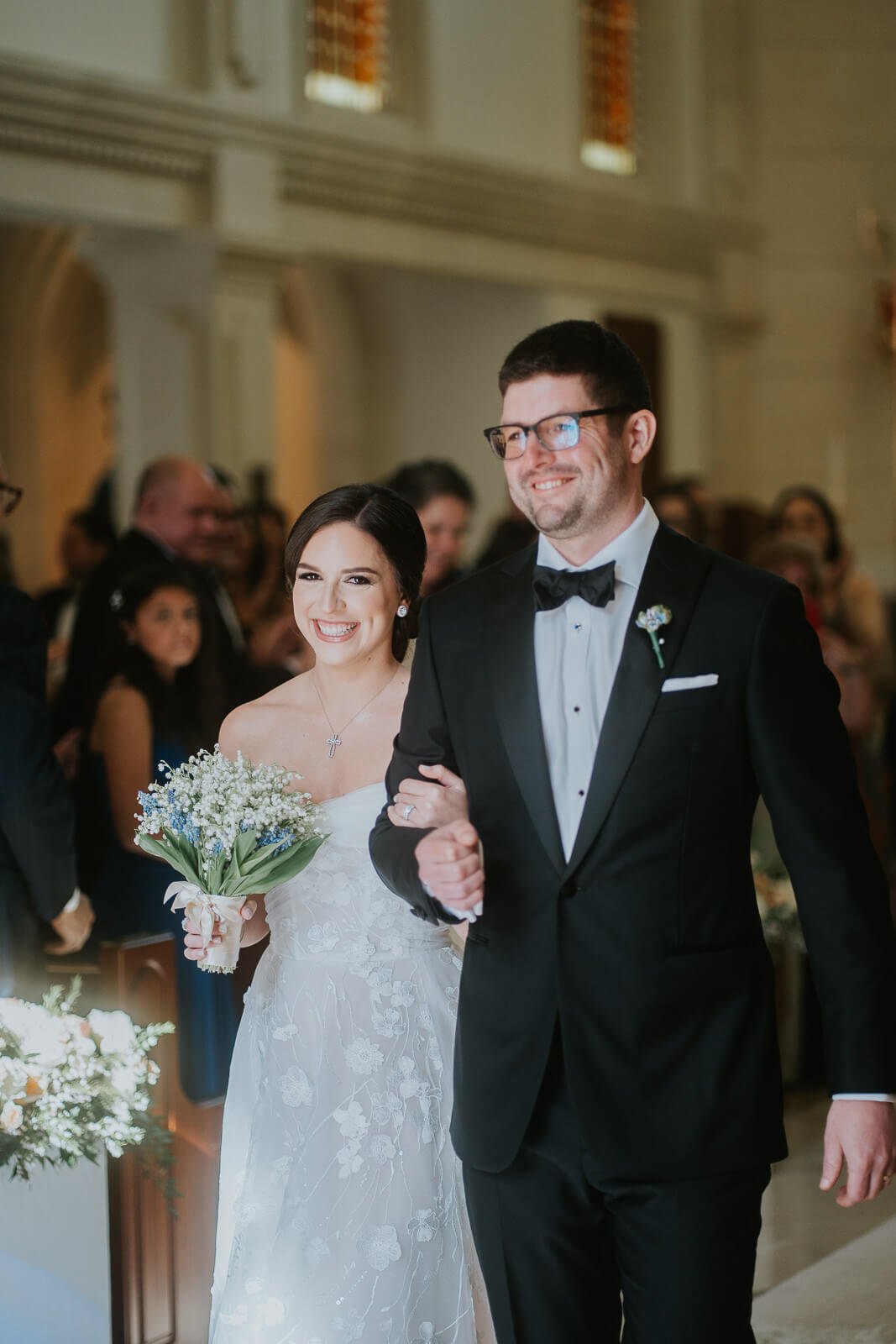 Wedding in San Juan Puerto Rico. Couple in wedding attire smiling as they walk out of the church. 